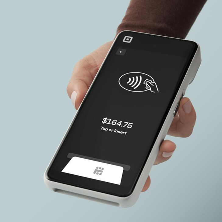 Square handheld device in apron pocket with tray of drinks